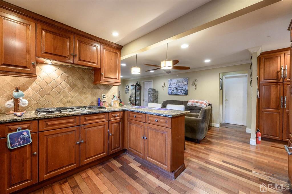 240 Lloyd Road Aberdeen, NJ 07747 - Photo 11 of 29 a kitchen with stainless steel appliances kitchen island granite countertop a stove refrigerator and cabinets