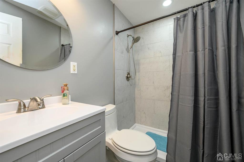 240 Lloyd Road Aberdeen, NJ 07747 - Photo 16 of 29 a bathroom with a sink a toilet and shower