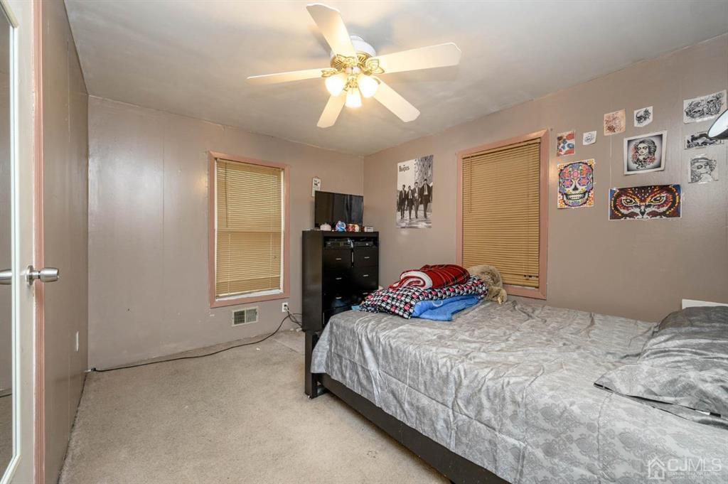 240 Lloyd Road Aberdeen, NJ 07747 - Photo 17 of 29 a bedroom with a bed and a chandelier