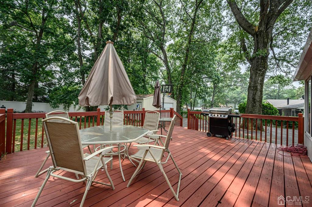 240 Lloyd Road Aberdeen, NJ 07747 - Photo 23 of 29 a view of a patio with table and chairs wooden floor and fence