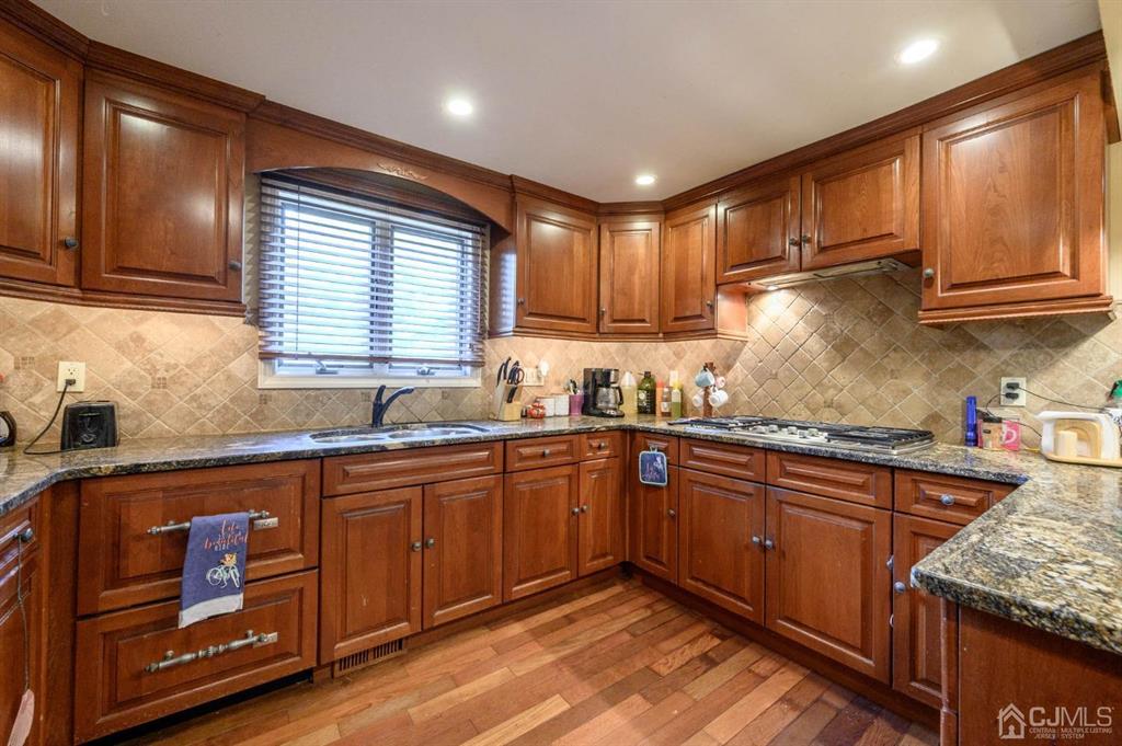240 Lloyd Road Aberdeen, NJ 07747 - Photo 7 of 29 a kitchen with granite countertop wooden cabinets stainless steel appliances a sink and a window