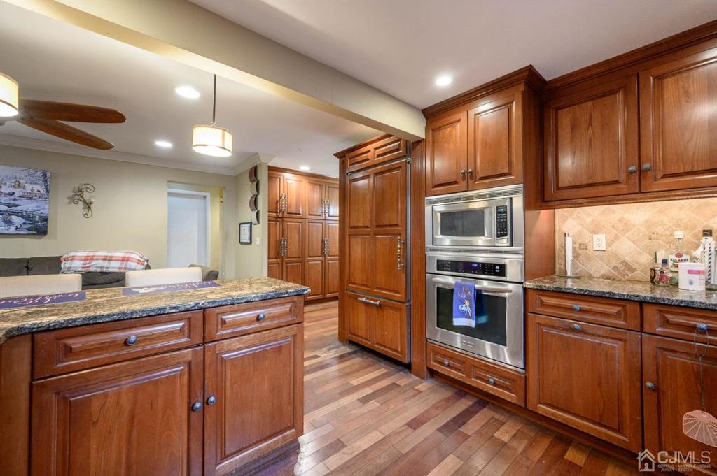 240 Lloyd Road Aberdeen, NJ 07747 - Photo 10 of 29 a kitchen with stainless steel appliances granite countertop a sink and wooden cabinets
