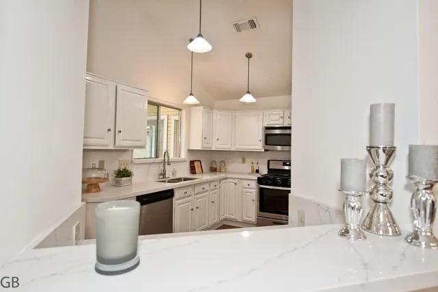 a kitchen with a sink stove and cabinets