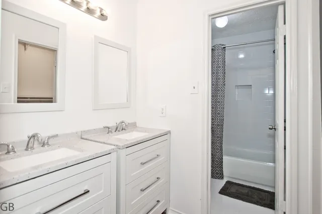 a bathroom with a shower sink vanity and mirror