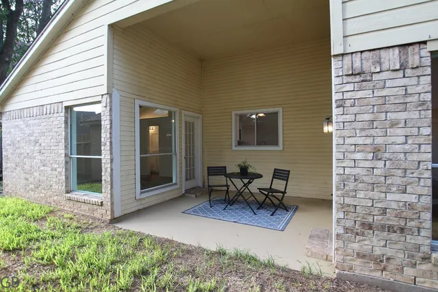 a view of a patio with table and chairs near a barn