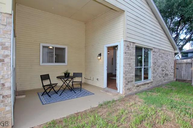 a view of a patio with table and chairs and wooden fence