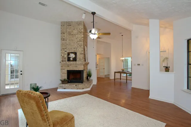 a living room with furniture a fireplace and a chandelier