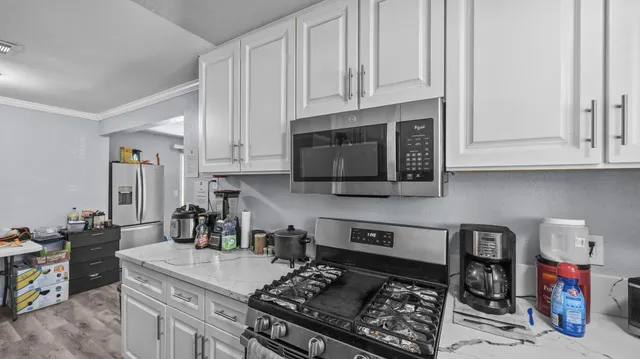 a kitchen with stainless steel appliances granite countertop a stove and a microwave