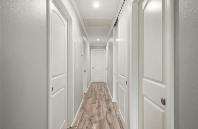 a view of a hallway with wooden floor and closet