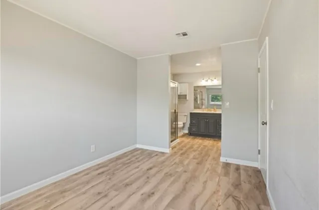 a view of a hallway with wooden floor and a kitchen