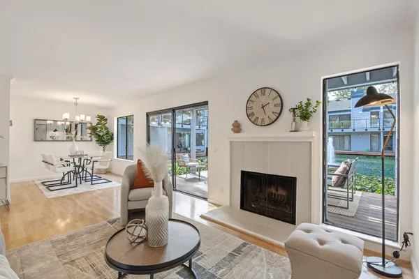 a living room with furniture a fireplace and a large window