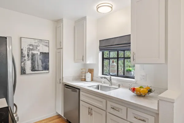 a kitchen with a sink large window and cabinets