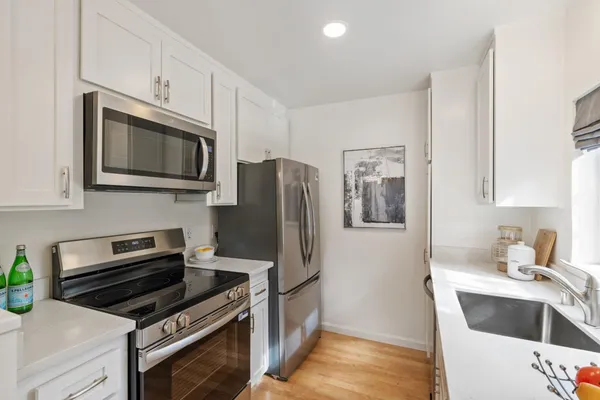 a kitchen with stainless steel appliances a stove a microwave and a refrigerator