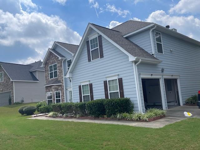 a front view of a house with a yard and potted plants