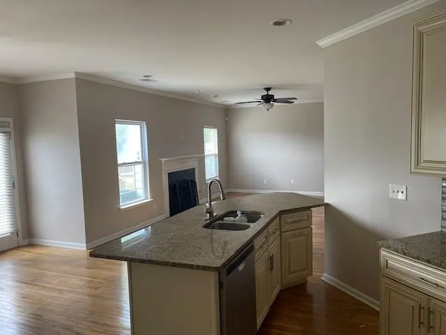 wooden floor in an empty room with a fireplace and a window