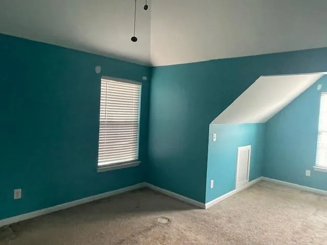 a view of an empty room with window and stairs