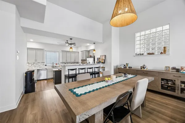 a dining room with stainless steel appliances kitchen island a table chairs and a kitchen view