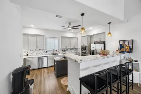 a kitchen with a stove a table and chairs in it
