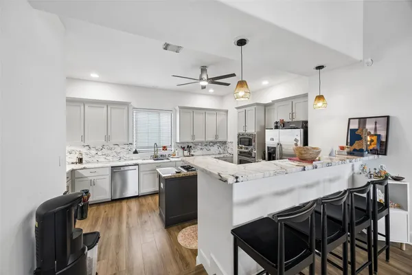 a kitchen with a stove a table and chairs in it