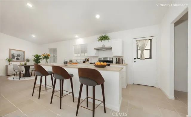 a kitchen with cabinets and chairs