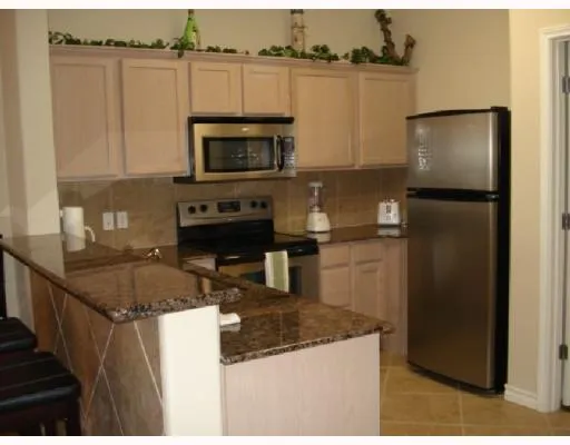 a kitchen with stainless steel appliances granite countertop a refrigerator a stove and a sink