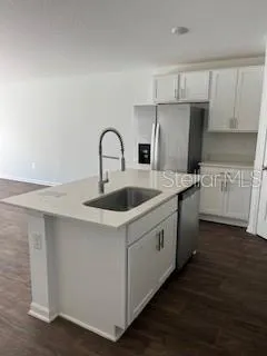 a kitchen with stainless steel appliances a sink a stove a refrigerator and cabinets