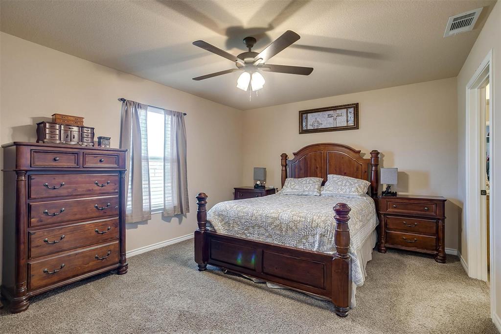 2140 Brown Loop Poolville, TX 76487 - Photo 14 of 38 a bedroom with a bed and a chandelier