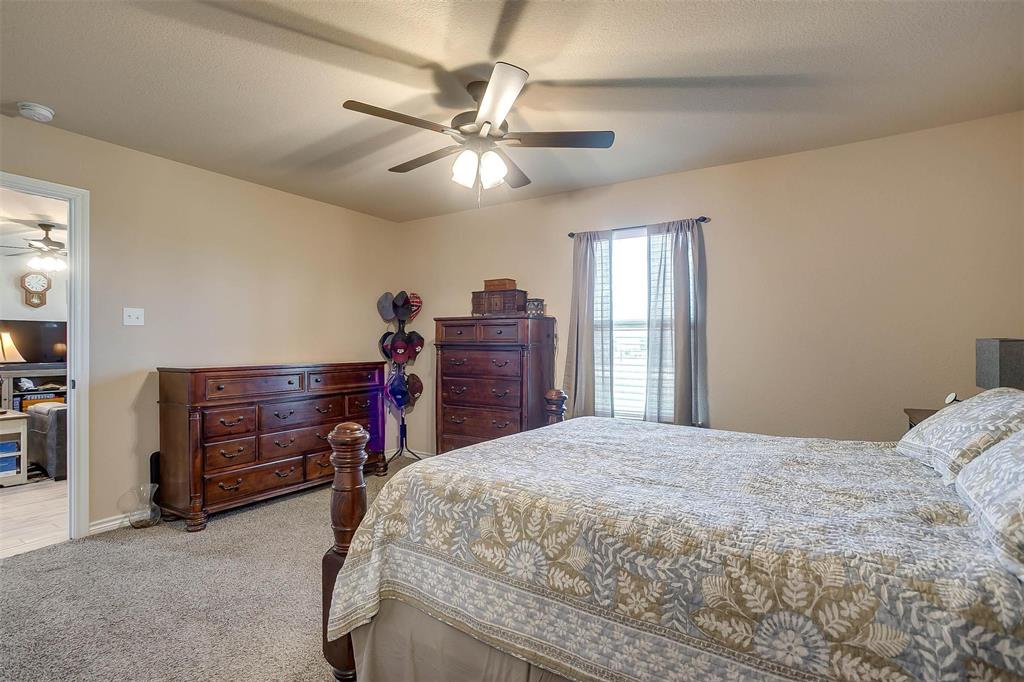 2140 Brown Loop Poolville, TX 76487 - Photo 16 of 38 a bedroom with a bed and a chandelier