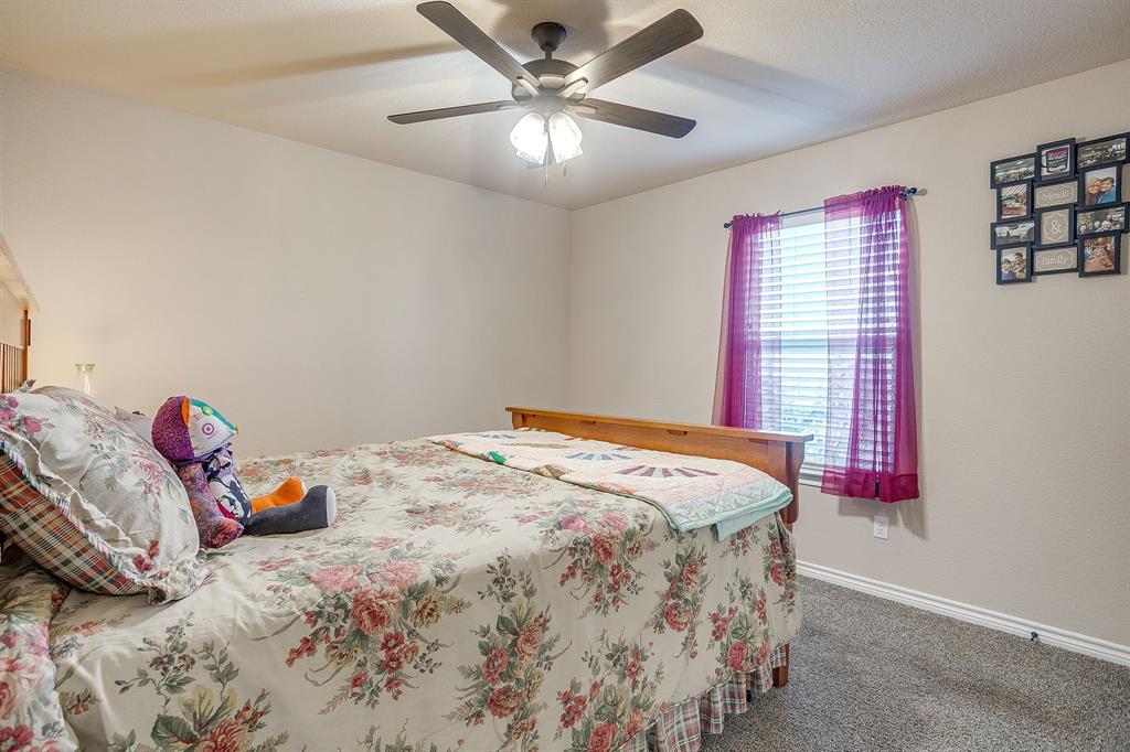 2140 Brown Loop Poolville, TX 76487 - Photo 19 of 38 a bedroom with a bed and a chandelier