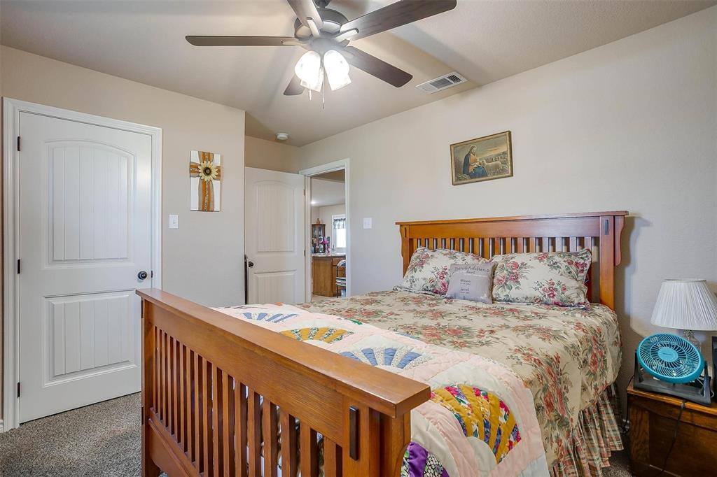 2140 Brown Loop Poolville, TX 76487 - Photo 20 of 38 a bedroom with a bed and a chandelier