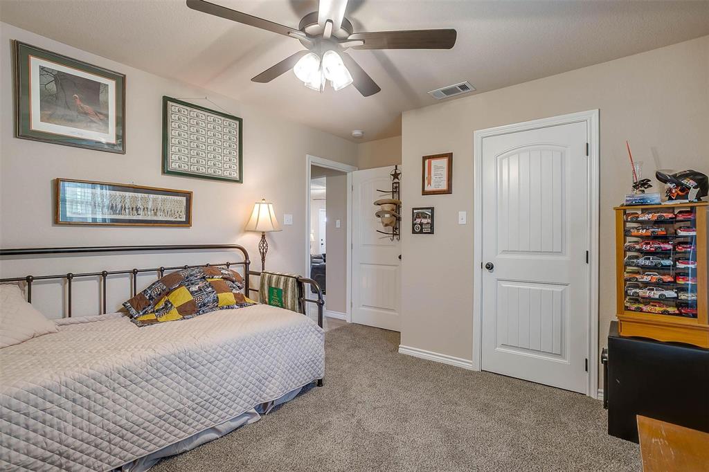 2140 Brown Loop Poolville, TX 76487 - Photo 23 of 38 a bedroom with a bed and a chandelier