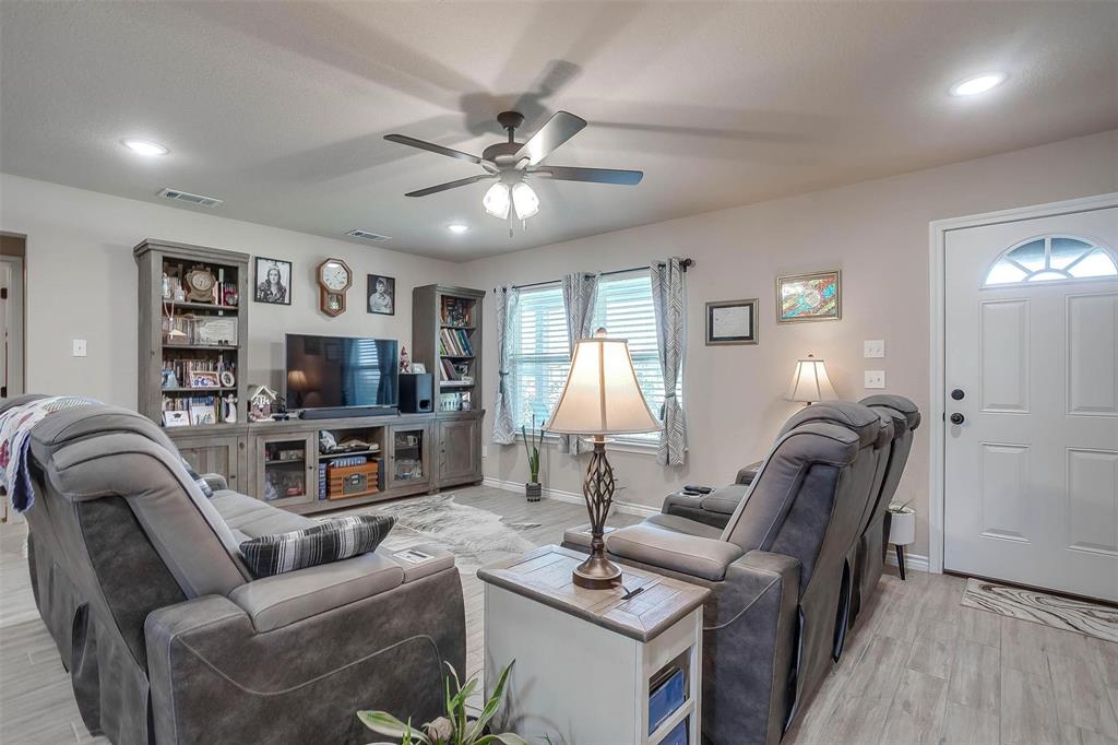 2140 Brown Loop Poolville, TX 76487 - Photo 3 of 38 a living room with furniture a ceiling fan and a flat screen tv