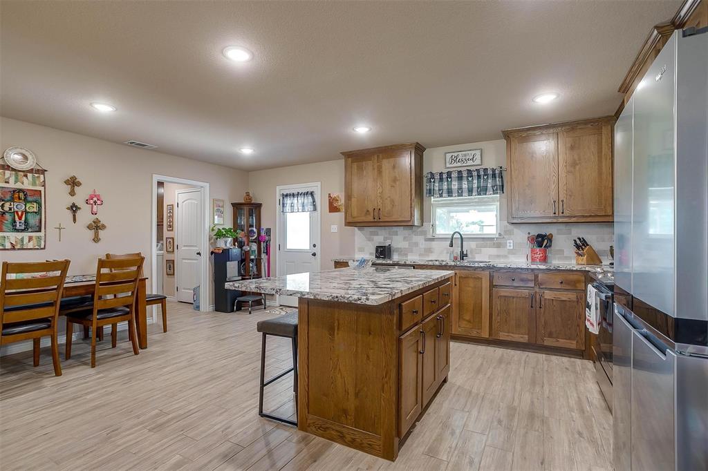 2140 Brown Loop Poolville, TX 76487 - Photo 10 of 38 a kitchen with kitchen island granite countertop lots of counter top space and stainless steel appliances