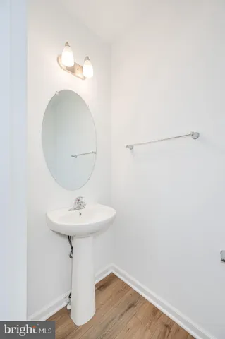 a large kitchen with granite countertop a stove top oven a sink a window and wooden floor