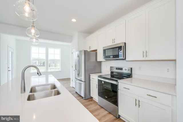 a kitchen with stainless steel appliances a refrigerator sink and microwave