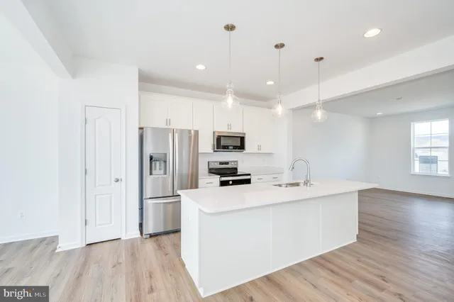 a kitchen with stainless steel appliances a refrigerator sink and microwave