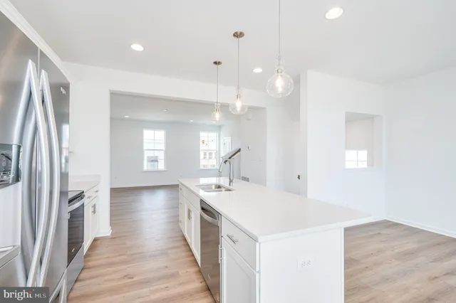 a dining hall with stainless steel appliances granite countertop a refrigerator and a sink