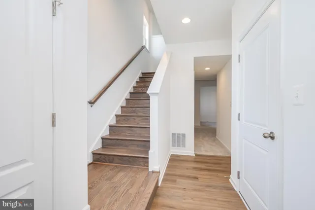 a view of a hallway with wooden floor and entryway
