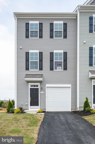 a view of a white house with a small yard and a large tree