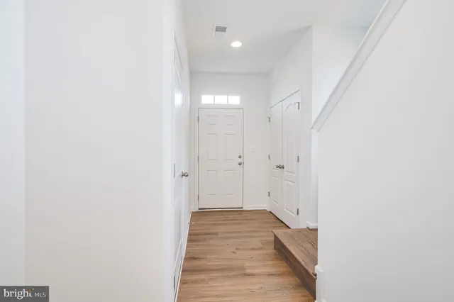 a view of a hallway with wooden floor