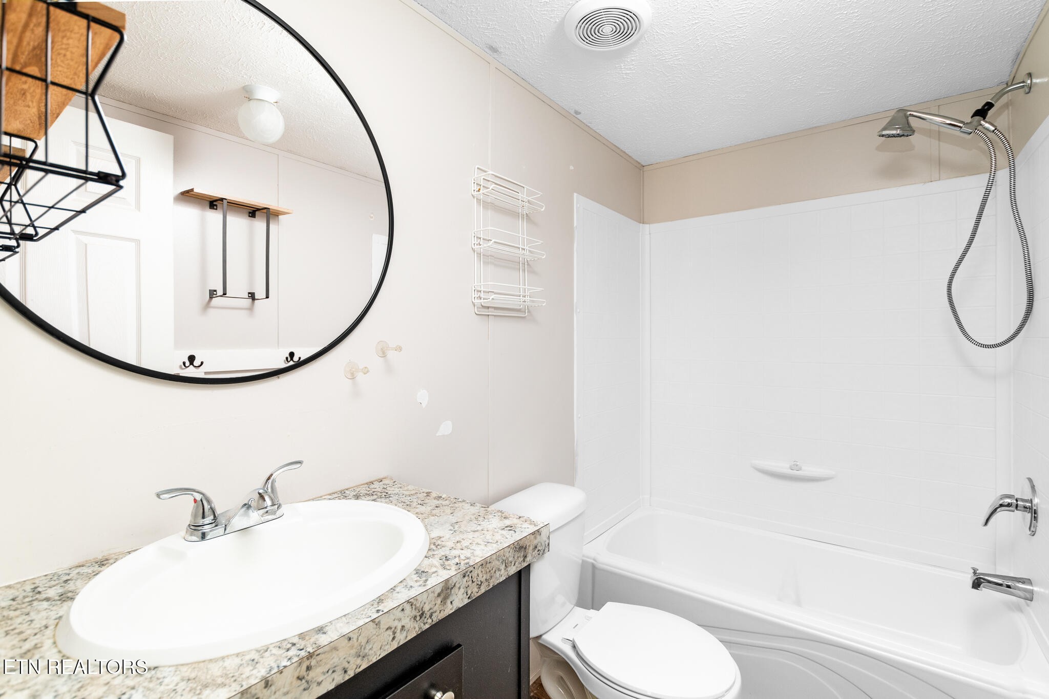 297 Wells Road Powell, TN 37849 - Photo 11 of 15 a bathroom with a granite countertop sink mirror toilet and bathtub