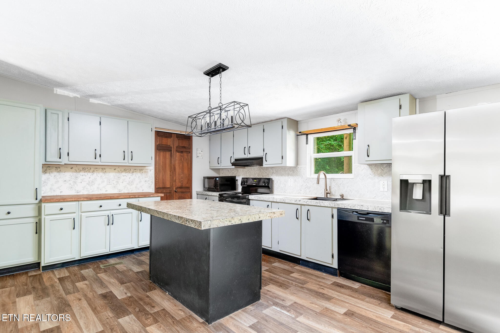 297 Wells Road Powell, TN 37849 - Photo 5 of 15 a kitchen with a sink a center island stainless steel appliances and cabinets