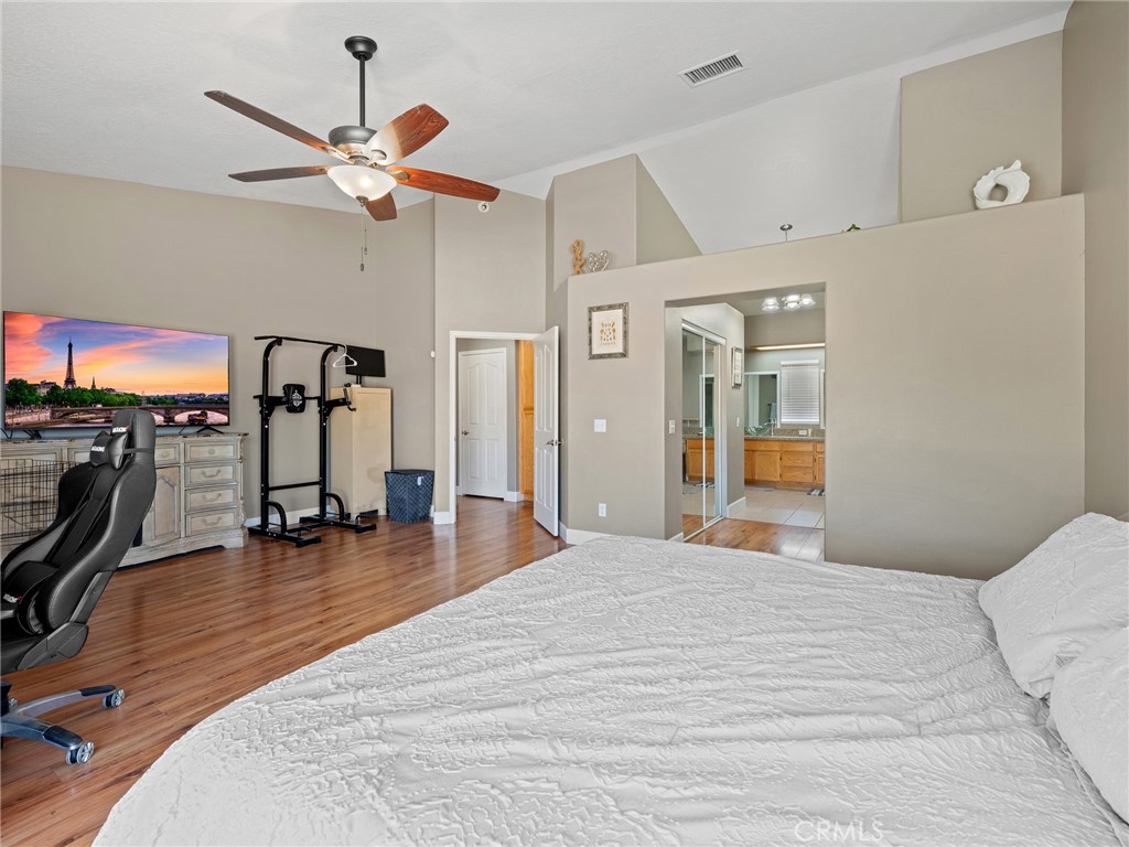 12949 Choco Road Apple Valley, CA 92308 - Photo 11 of 48 a bedroom with a bed and a chandelier