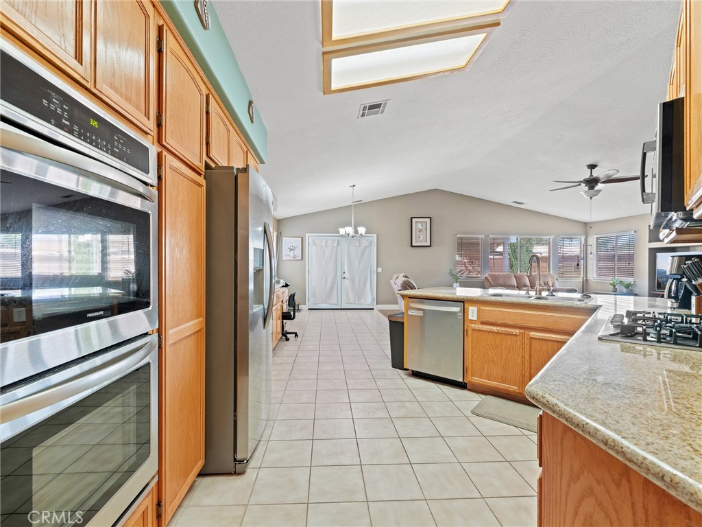 12949 Choco Road Apple Valley, CA 92308 - Photo 15 of 48 a large kitchen with granite countertop a large stove a sink dishwasher and a stove