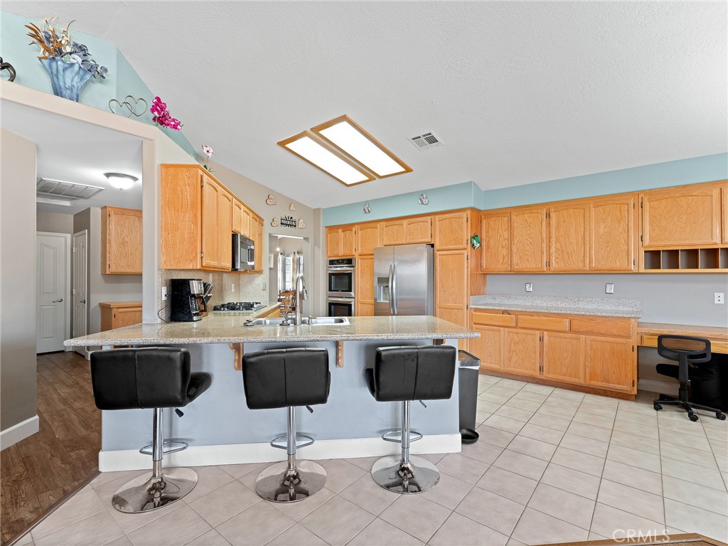 12949 Choco Road Apple Valley, CA 92308 - Photo 20 of 48 a kitchen with stainless steel appliances kitchen island granite countertop a sink and cabinets