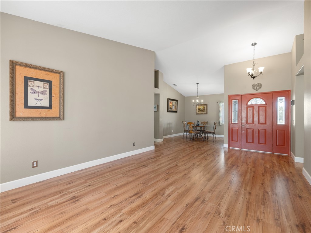 12949 Choco Road Apple Valley, CA 92308 - Photo 9 of 48 a view of a room with wooden floor a ceiling fan and windows