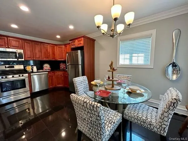 a view of a dining room with furniture a chandelier and wooden floor