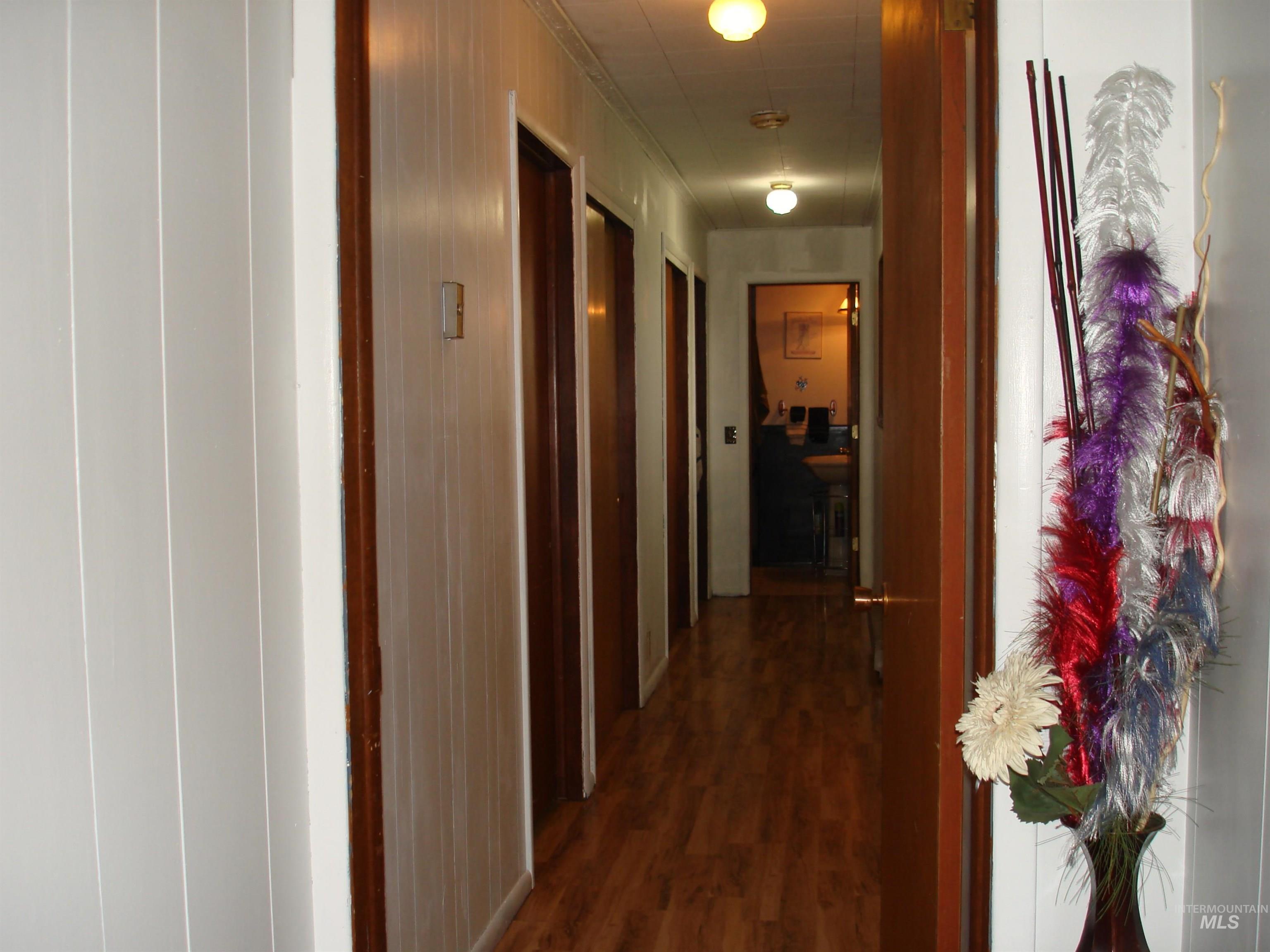 3756 Farrell Road New Meadows, ID 83654 - Photo 19 of 48 Corridor with wood-finish flooring, white paneled walls, and multiple interior doors