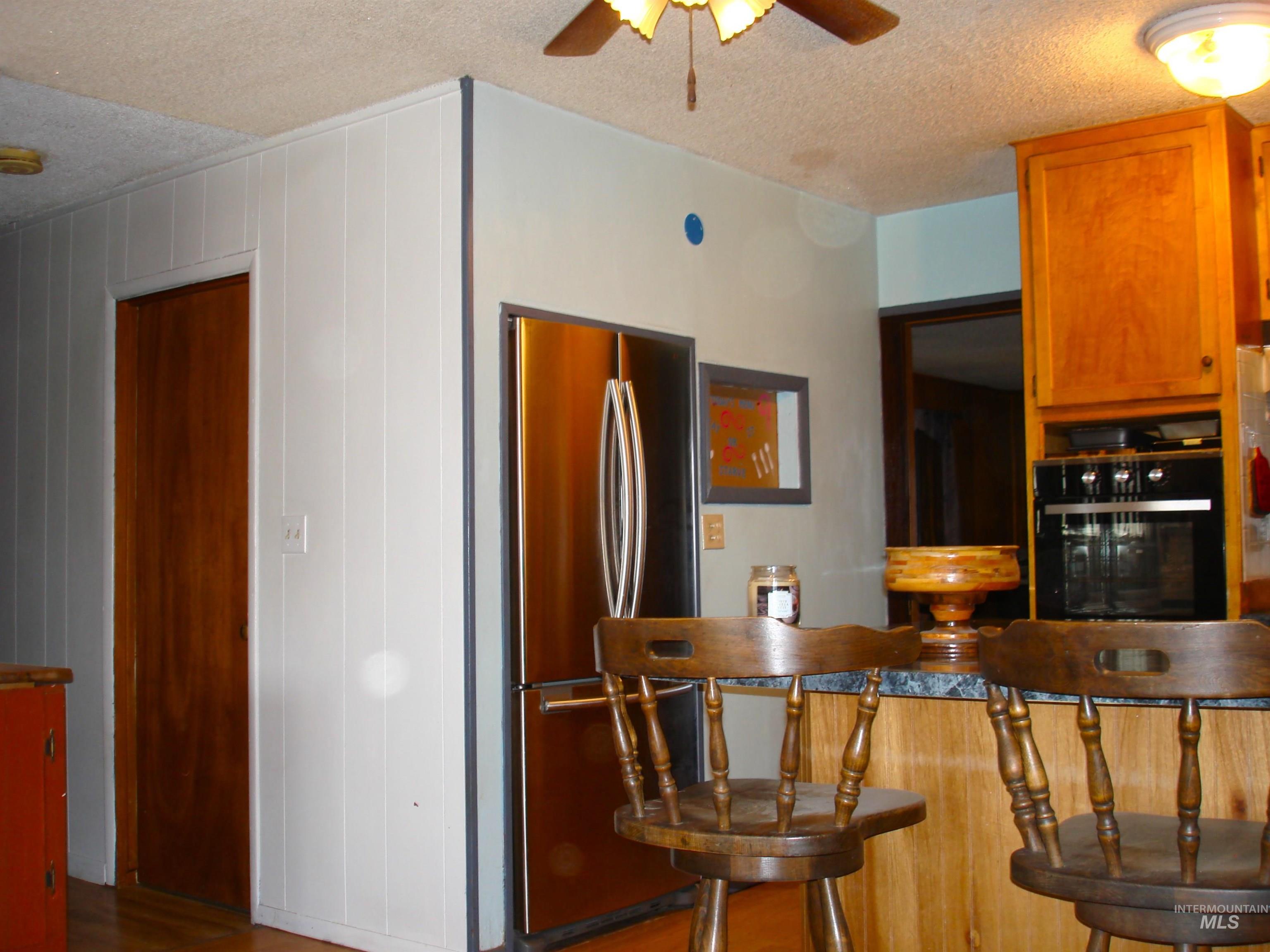 3756 Farrell Road New Meadows, ID 83654 - Photo 7 of 50 Kitchen with a textured ceiling, freestanding refrigerator, a ceiling fan, black oven, and dark countertops