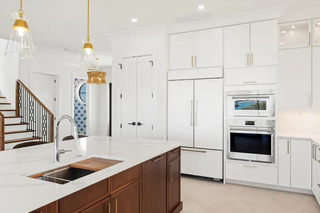a kitchen with stainless steel appliances granite countertop a sink and a refrigerator